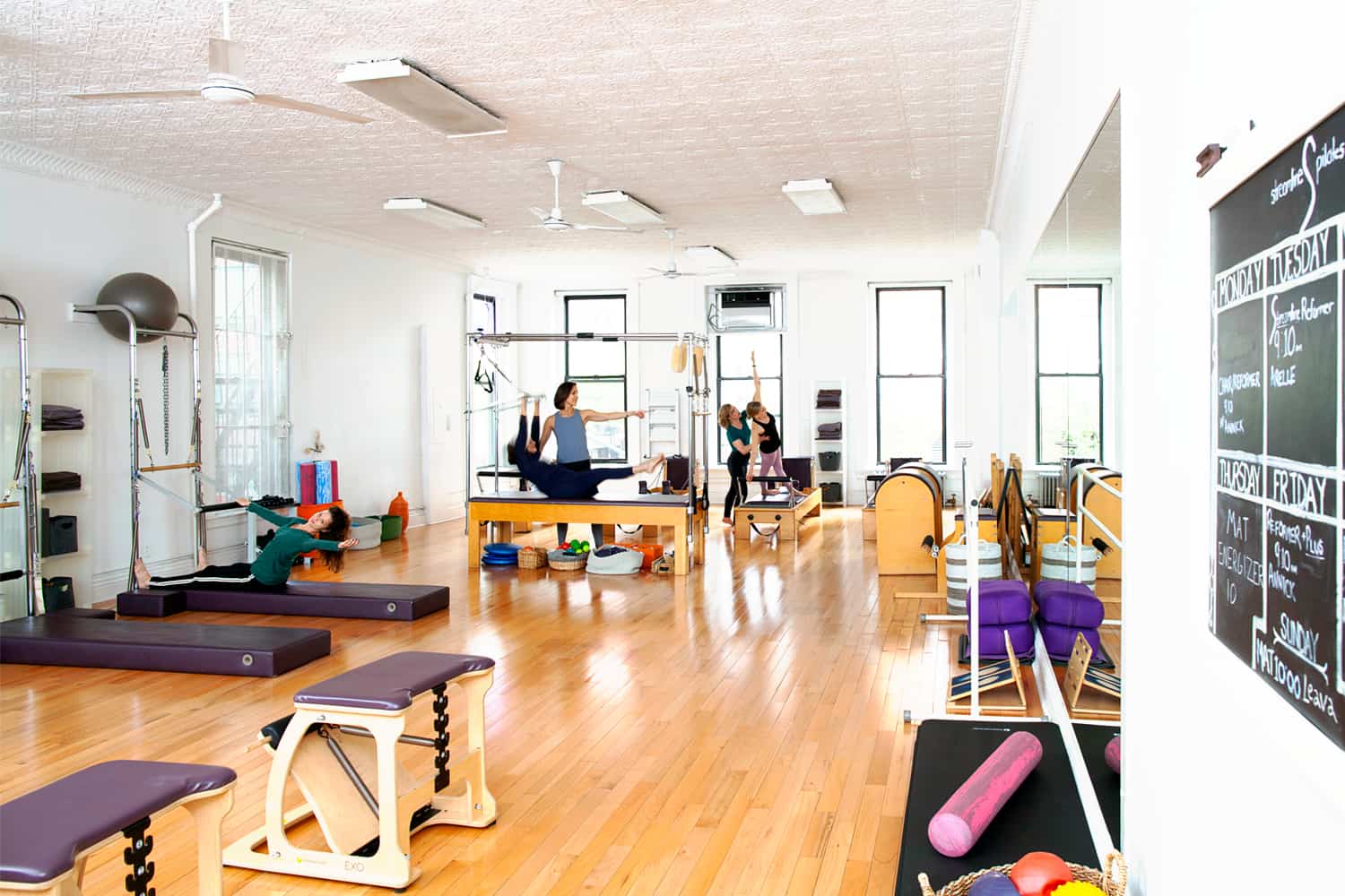Pilates studio in Brooklyn, NY. People performing exercises.