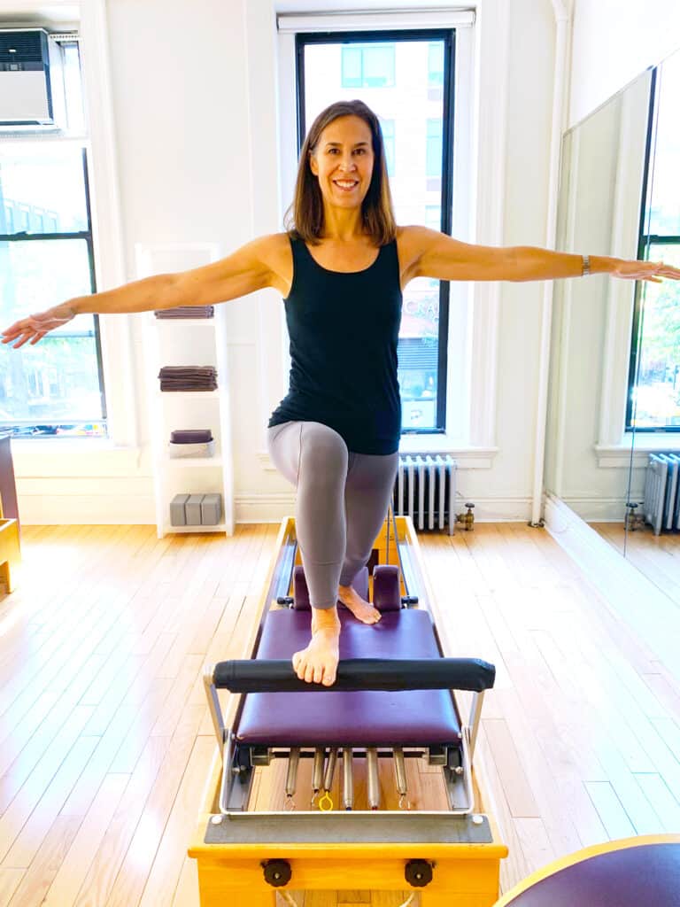 Pilates instructor doing a lunge on the reformer