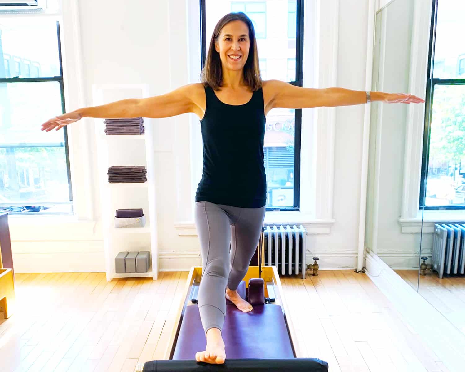 Pilates instructor doing a lunge on the reformer