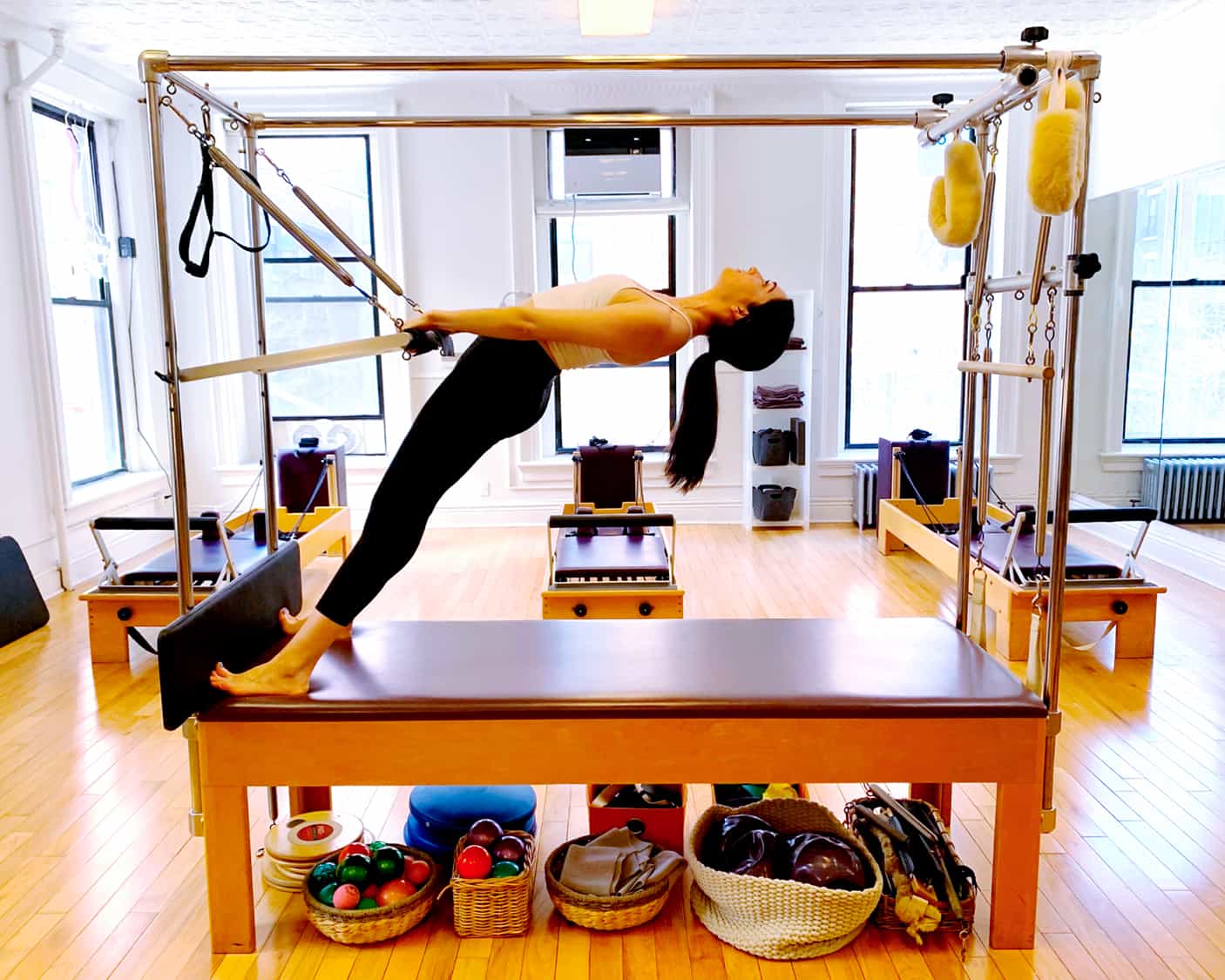 Pilates Instructor performing Bridging on the Trapeze Table. Pilates the long-term game.