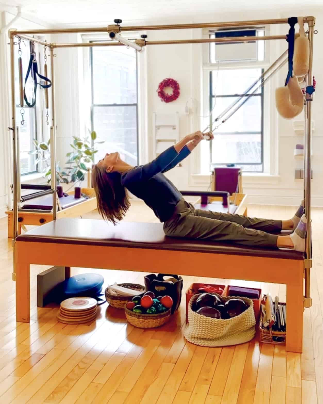 roll down (arch and curl) on the Pilates Trapeze Table, springs for arms and core, extension for back